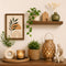 Modern home décor setup with wooden floating shelf, indoor plants, candle lantern, ceramic vase, boho decorative accessories, and minimalist wall art in warm neutral interior design style.